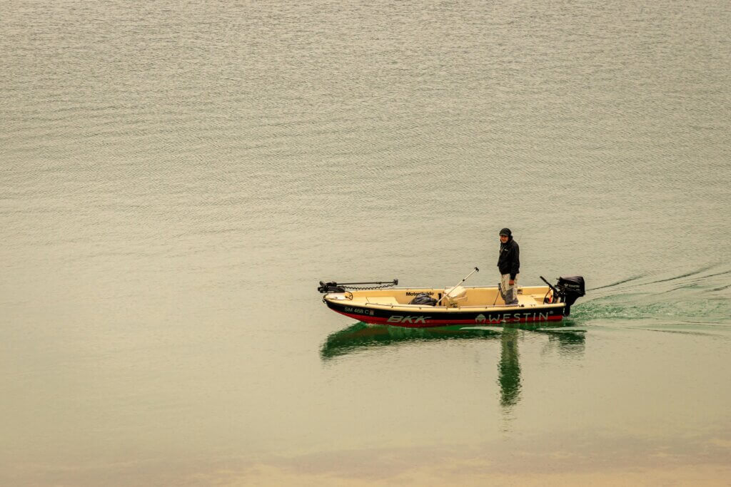 pêcheur seul debout sur son bateau